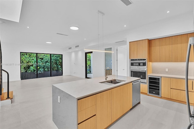 kitchen featuring stainless steel appliances, wine cooler, a center island with sink, and a healthy amount of sunlight