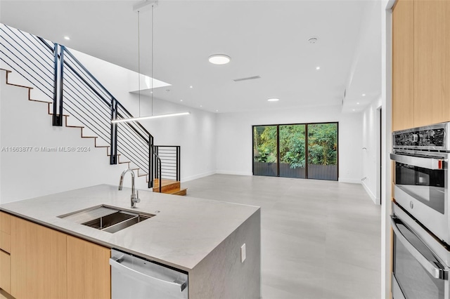 kitchen featuring light brown cabinets, stainless steel appliances, and sink