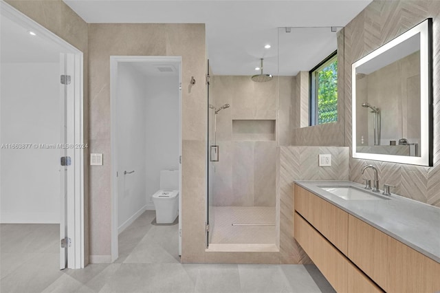 bathroom with vanity, an enclosed shower, tile patterned floors, tile walls, and toilet