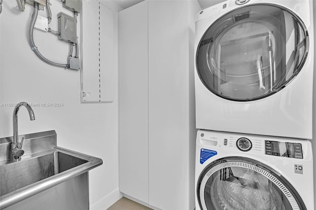 laundry room featuring stacked washer / dryer and sink