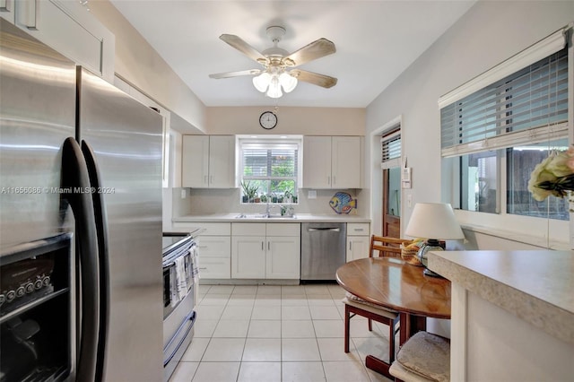 kitchen featuring sink, white cabinetry, stainless steel appliances, backsplash, and ceiling fan