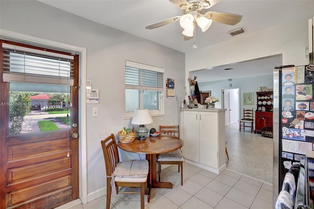 carpeted dining area with ceiling fan