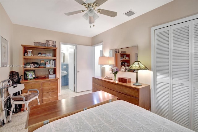 bedroom featuring a closet, ceiling fan, light colored carpet, and connected bathroom