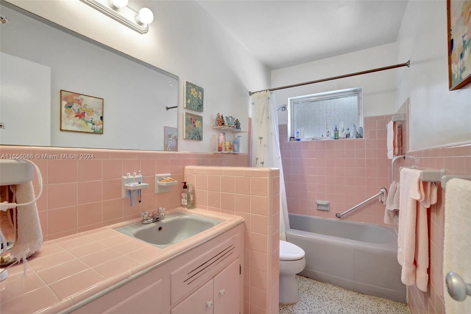 full bathroom with tile walls, shower / tub combo with curtain, vanity, and toilet