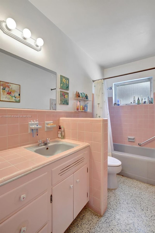 full bathroom with tile walls, backsplash, vanity, shower / tub combo with curtain, and toilet