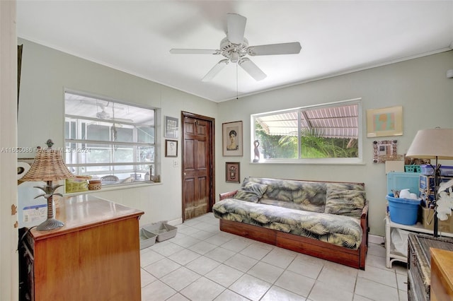 living room with ceiling fan, ornamental molding, and light tile patterned floors