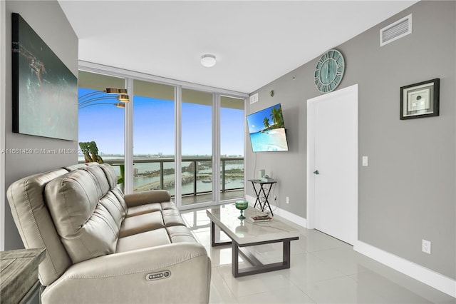 living room featuring light tile patterned floors and a wall of windows