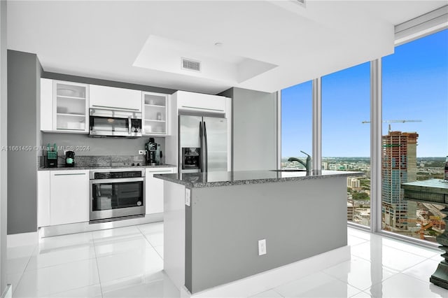 kitchen with white cabinetry, light tile patterned floors, a healthy amount of sunlight, and appliances with stainless steel finishes