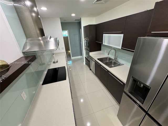 kitchen featuring stainless steel appliances, exhaust hood, light tile patterned flooring, and sink