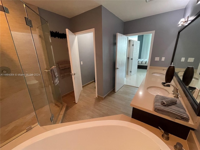 bathroom featuring independent shower and bath, hardwood / wood-style flooring, and vanity