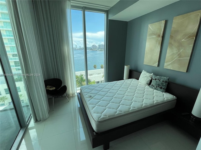 tiled bedroom with multiple windows and a water view