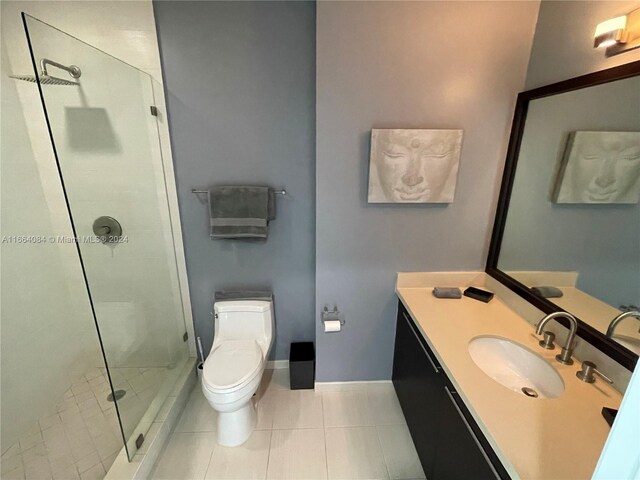 bathroom featuring vanity, a shower with shower door, toilet, and tile patterned flooring