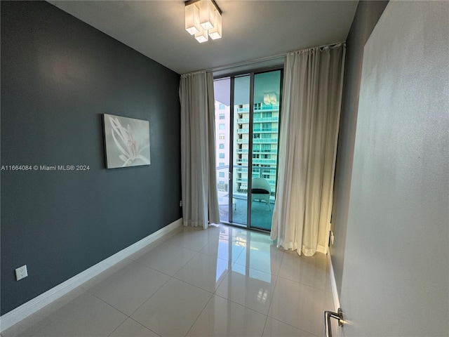 tiled spare room featuring expansive windows