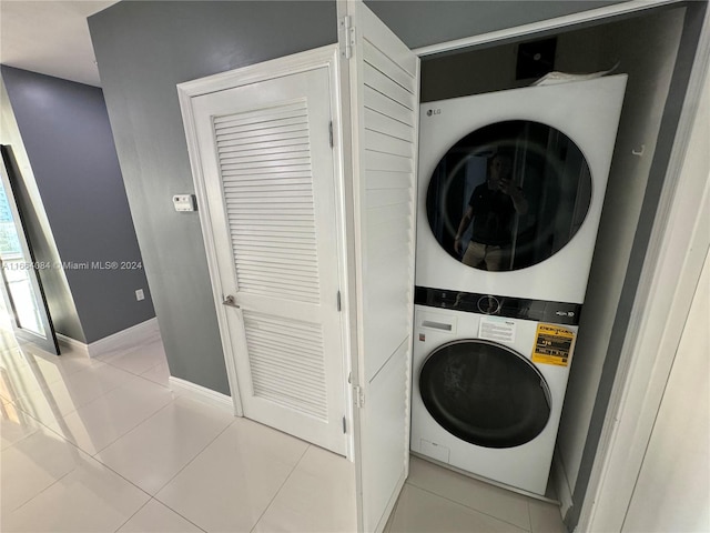 clothes washing area with stacked washer and dryer and light tile patterned floors