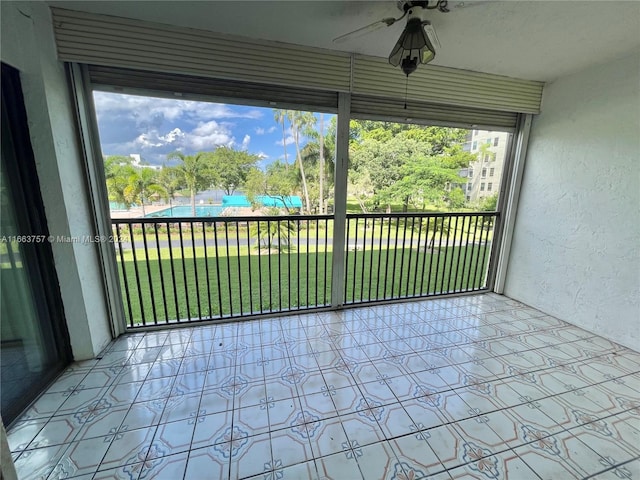 unfurnished sunroom with ceiling fan