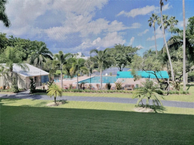 view of pool with a lawn