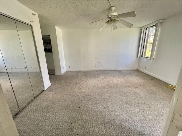 unfurnished bedroom featuring ceiling fan, light colored carpet, and a textured ceiling