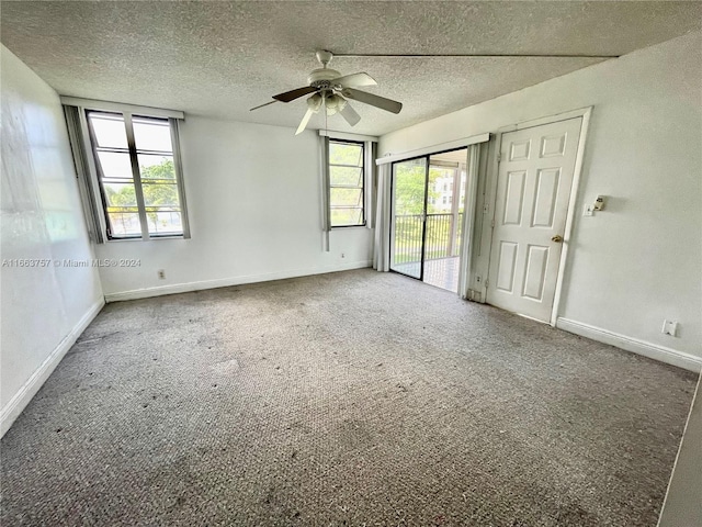 interior space with ceiling fan, a textured ceiling, access to exterior, and multiple windows