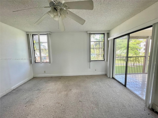 carpeted spare room featuring ceiling fan and a textured ceiling