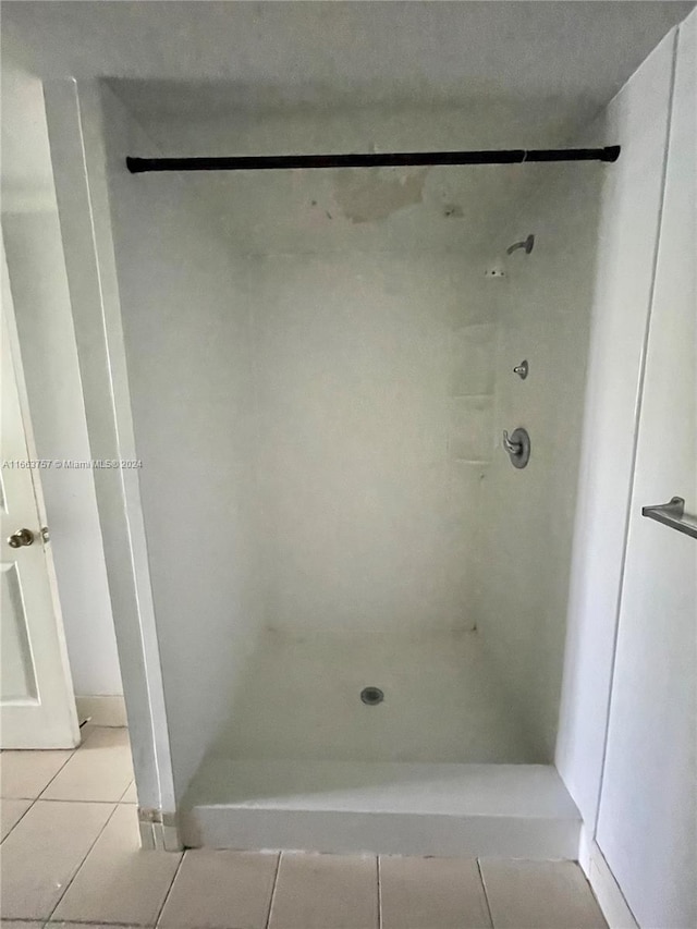 bathroom featuring tile patterned flooring and tiled shower