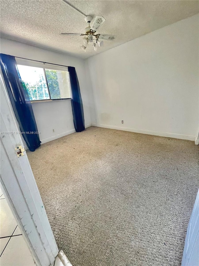 unfurnished bedroom with ceiling fan, light colored carpet, and a textured ceiling