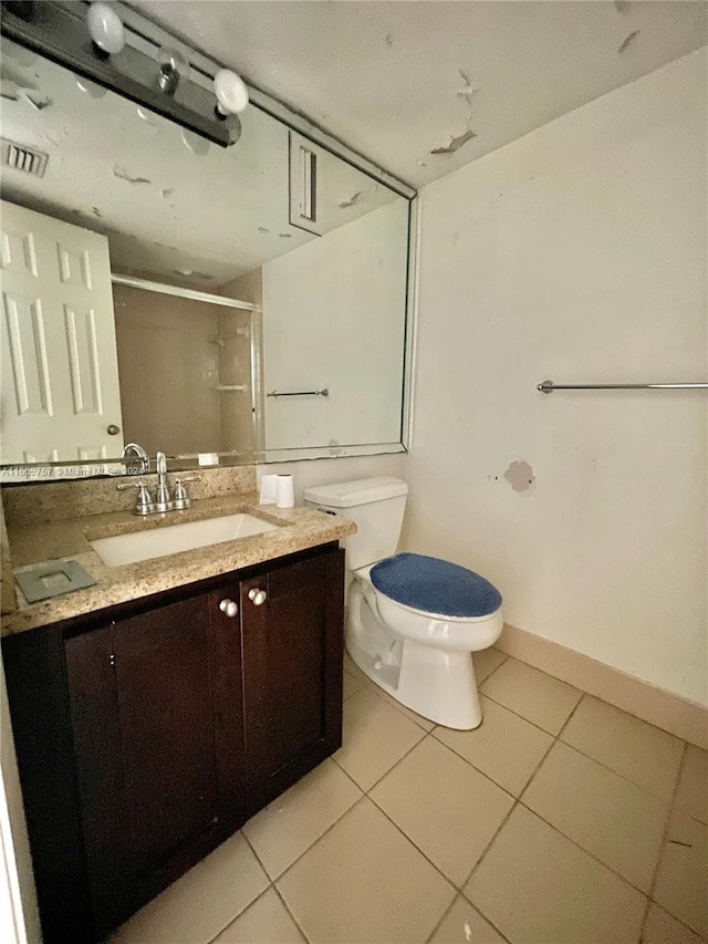 bathroom featuring vanity, tile patterned flooring, an enclosed shower, and toilet