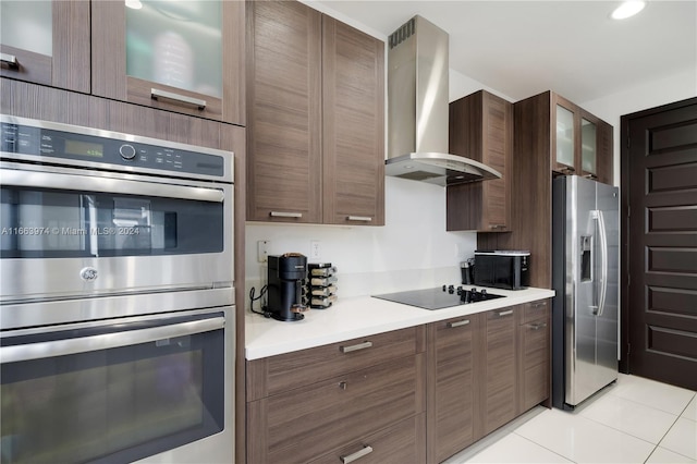 kitchen with light tile patterned flooring, appliances with stainless steel finishes, and wall chimney range hood