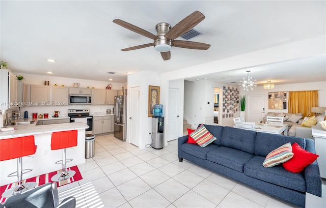 tiled living room with ceiling fan with notable chandelier and sink