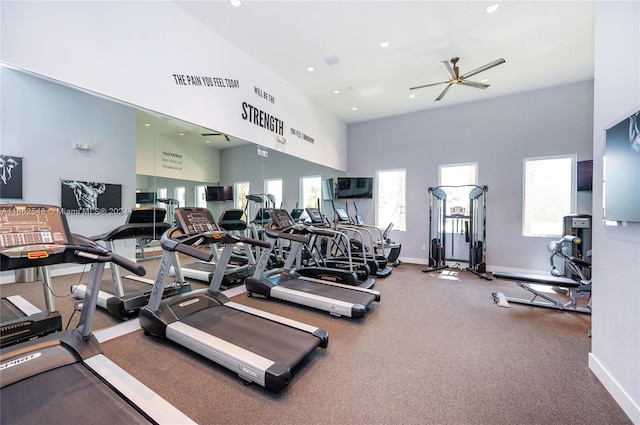 workout area with ceiling fan and a high ceiling