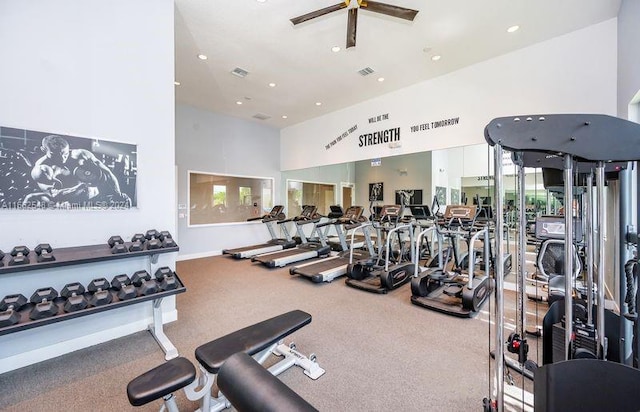 workout area with ceiling fan and a high ceiling