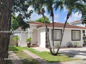 mediterranean / spanish-style home featuring fence, a tiled roof, and stucco siding