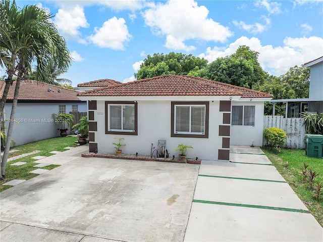 back of house with stucco siding, a tile roof, fence, and a patio