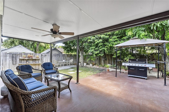 view of patio with a gazebo, area for grilling, a ceiling fan, a fenced backyard, and an outdoor living space