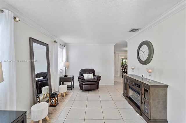 living room with a textured ceiling, plenty of natural light, light tile patterned flooring, and crown molding