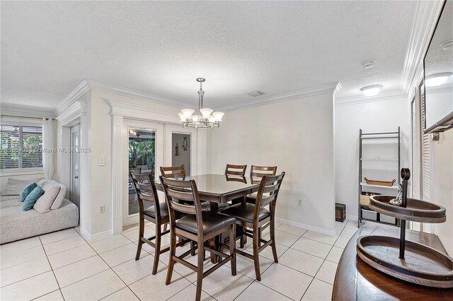 dining room with light tile patterned floors, a textured ceiling, an inviting chandelier, and crown molding