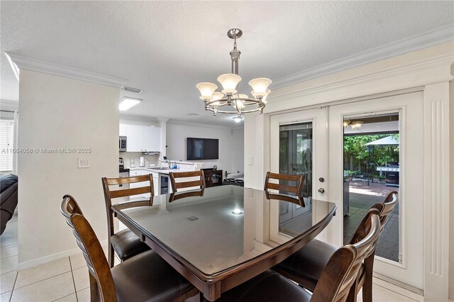 dining area with ornamental molding, light tile patterned floors, a textured ceiling, and an inviting chandelier