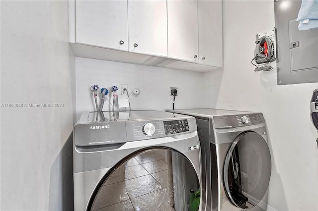 laundry area with electric panel, cabinets, and washing machine and dryer