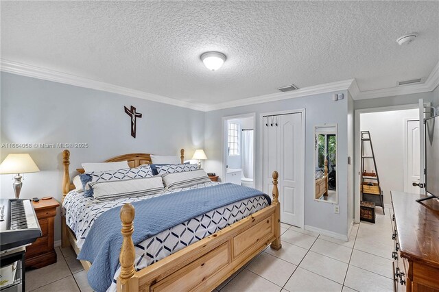 bedroom featuring a textured ceiling, ensuite bathroom, ornamental molding, and light tile patterned flooring