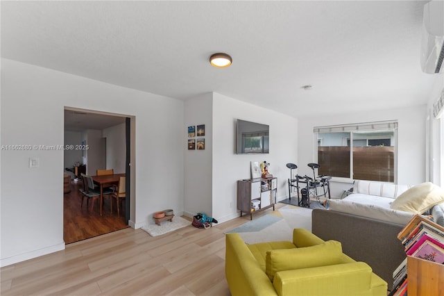 living room featuring light hardwood / wood-style floors and a wall unit AC