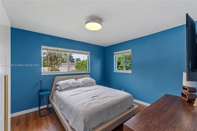 bedroom with dark hardwood / wood-style flooring and a textured ceiling