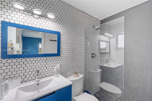 bathroom featuring toilet, a tile shower, backsplash, and vanity