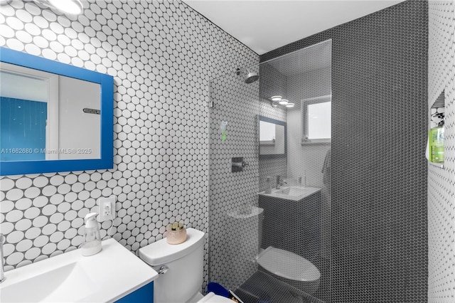 bathroom with a tile shower, decorative backsplash, vanity, and toilet