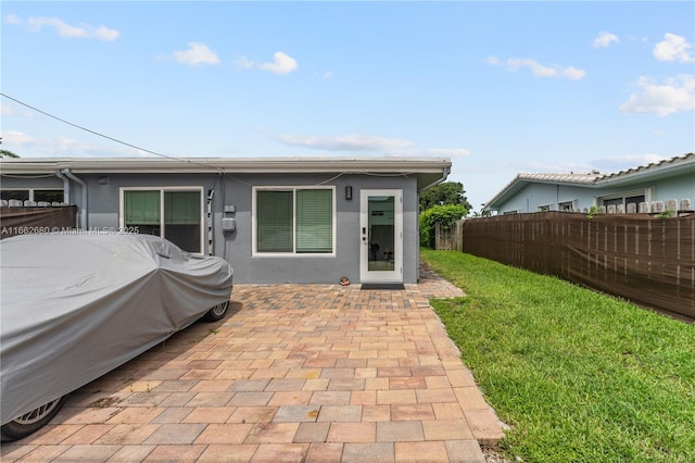 rear view of house featuring a yard and a patio