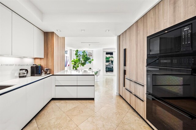 kitchen featuring light countertops, black appliances, modern cabinets, and white cabinetry