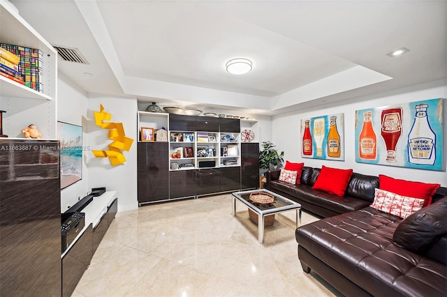 living area featuring marble finish floor and a raised ceiling