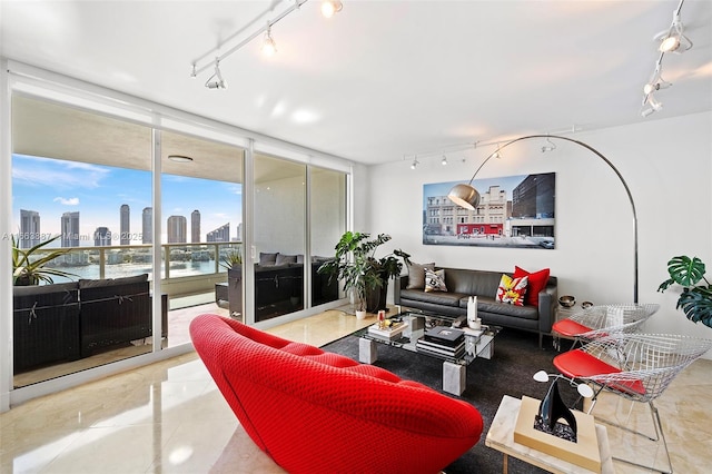 living area with a view of city, a water view, tile patterned flooring, and track lighting