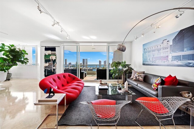 living area featuring rail lighting, a view of city, and floor to ceiling windows