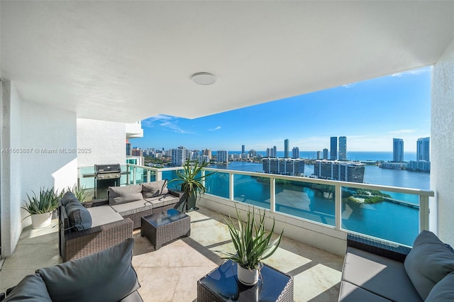 balcony featuring a grill, a city view, a water view, and an outdoor living space