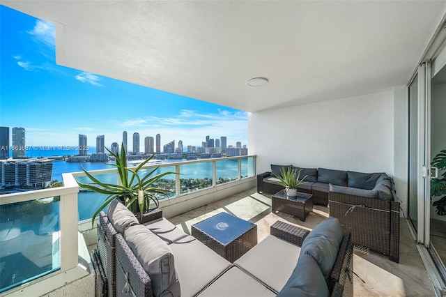 balcony featuring a city view, a water view, and an outdoor hangout area