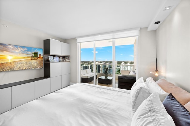 bedroom with access to exterior and a wall of windows